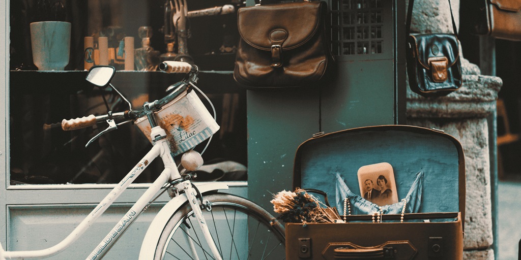 Kirpputoritavaraa: vanha polkupyörä, avoin vanha matkalaukku, kuva